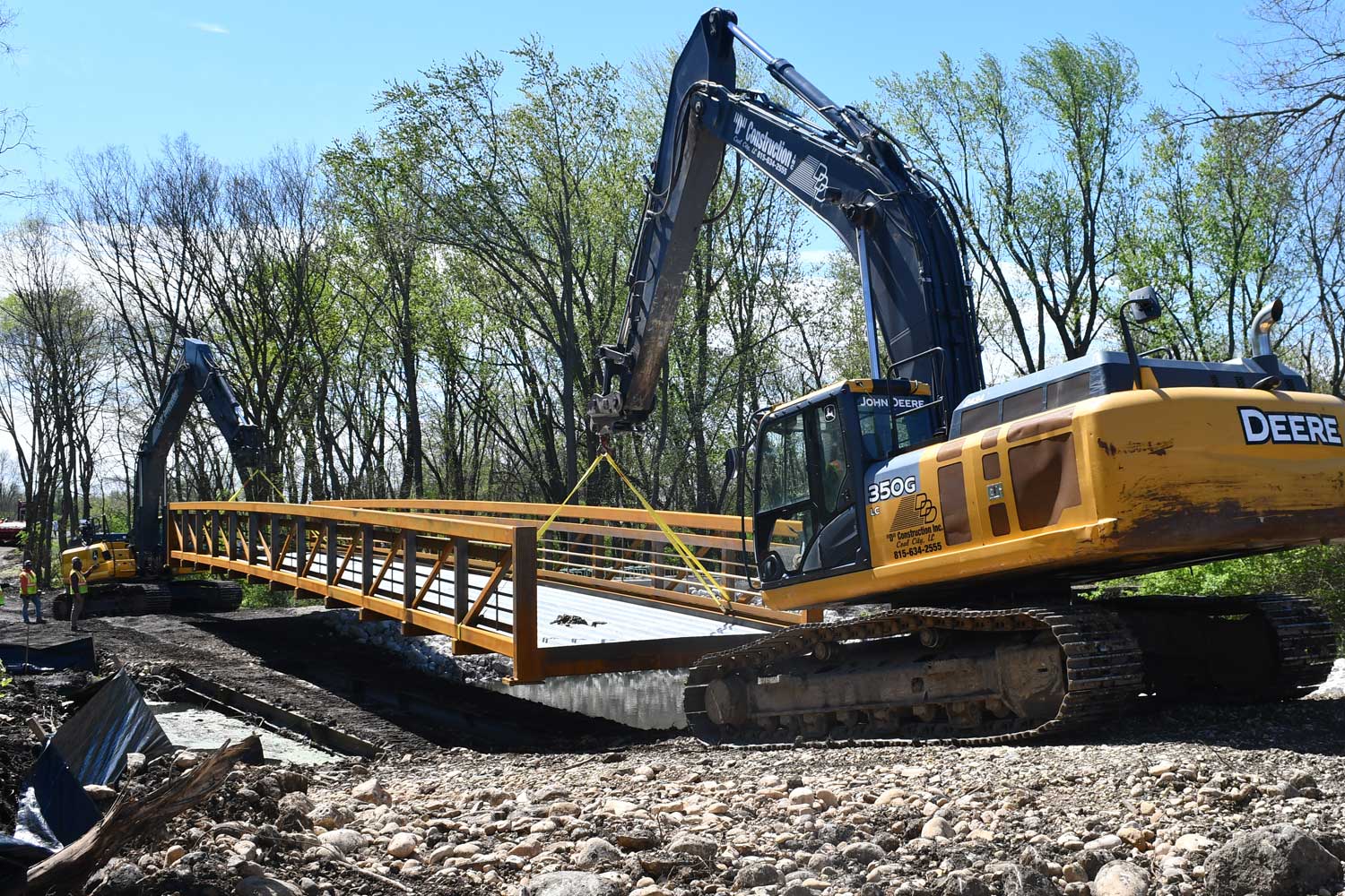 Construction vehicles moving bridge.