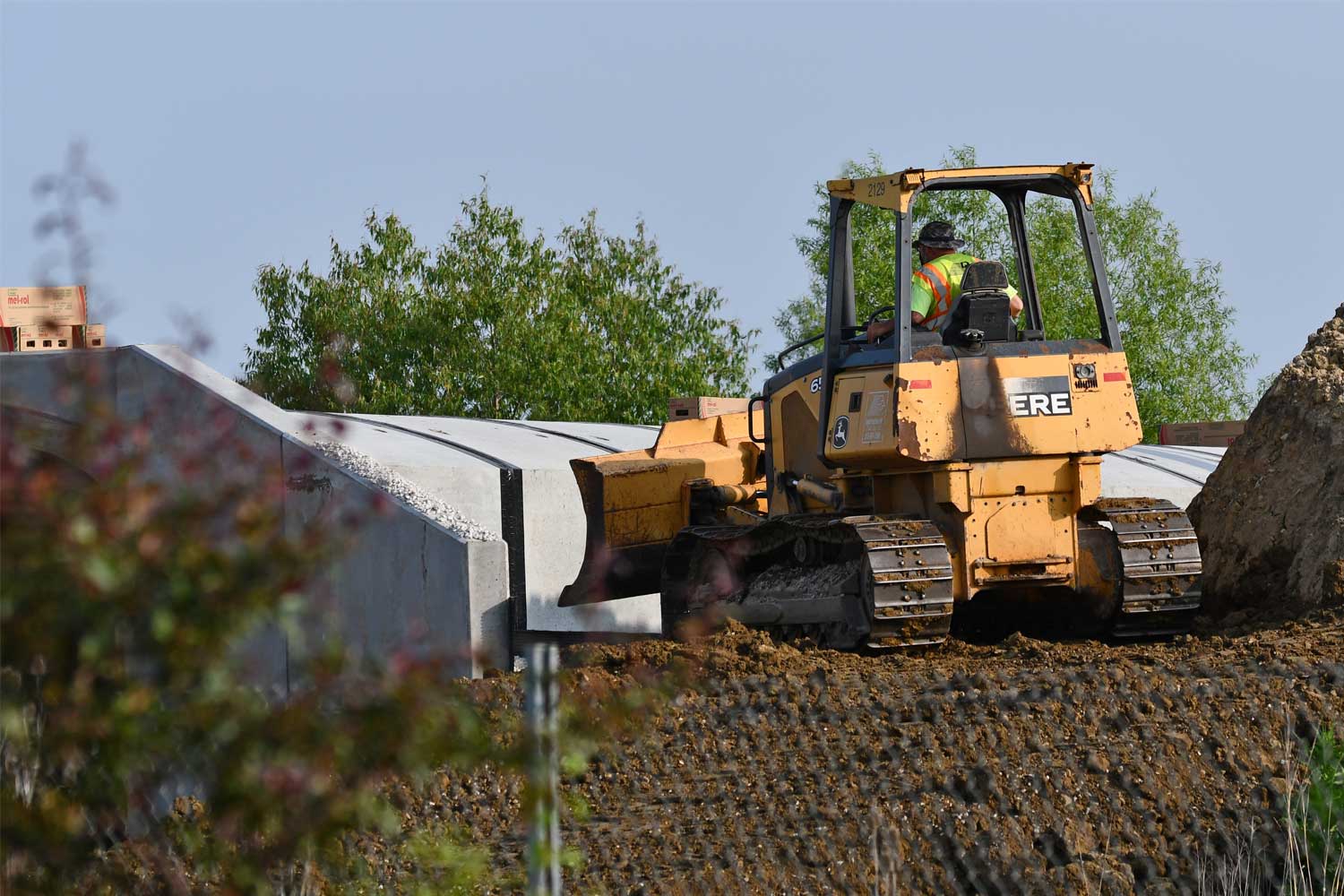 A bulldozer moves dirt along a new trail
