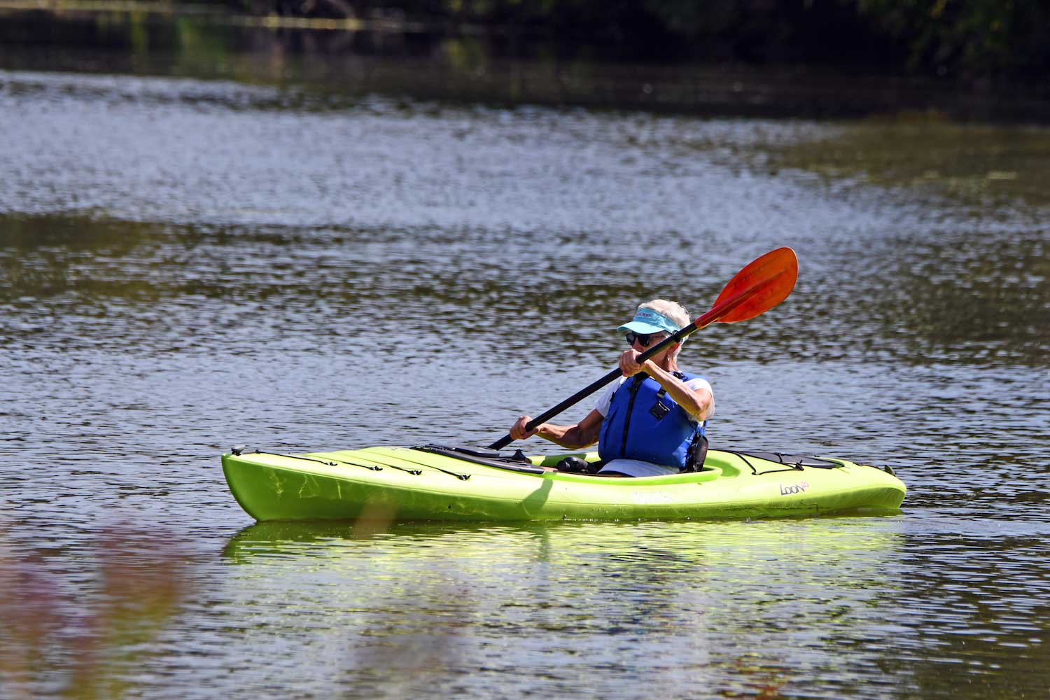 A person paddling on a lake in a kayak.