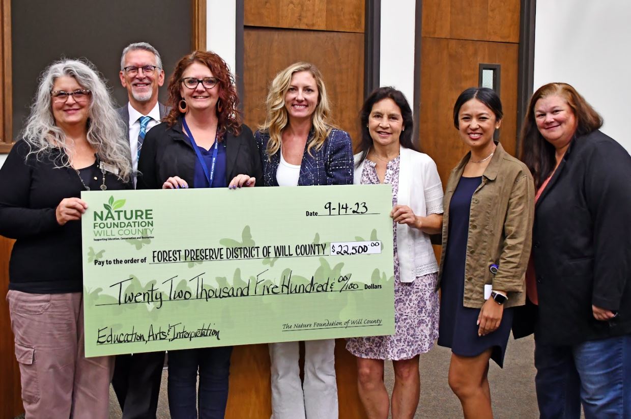 Officials holding an oversized check.