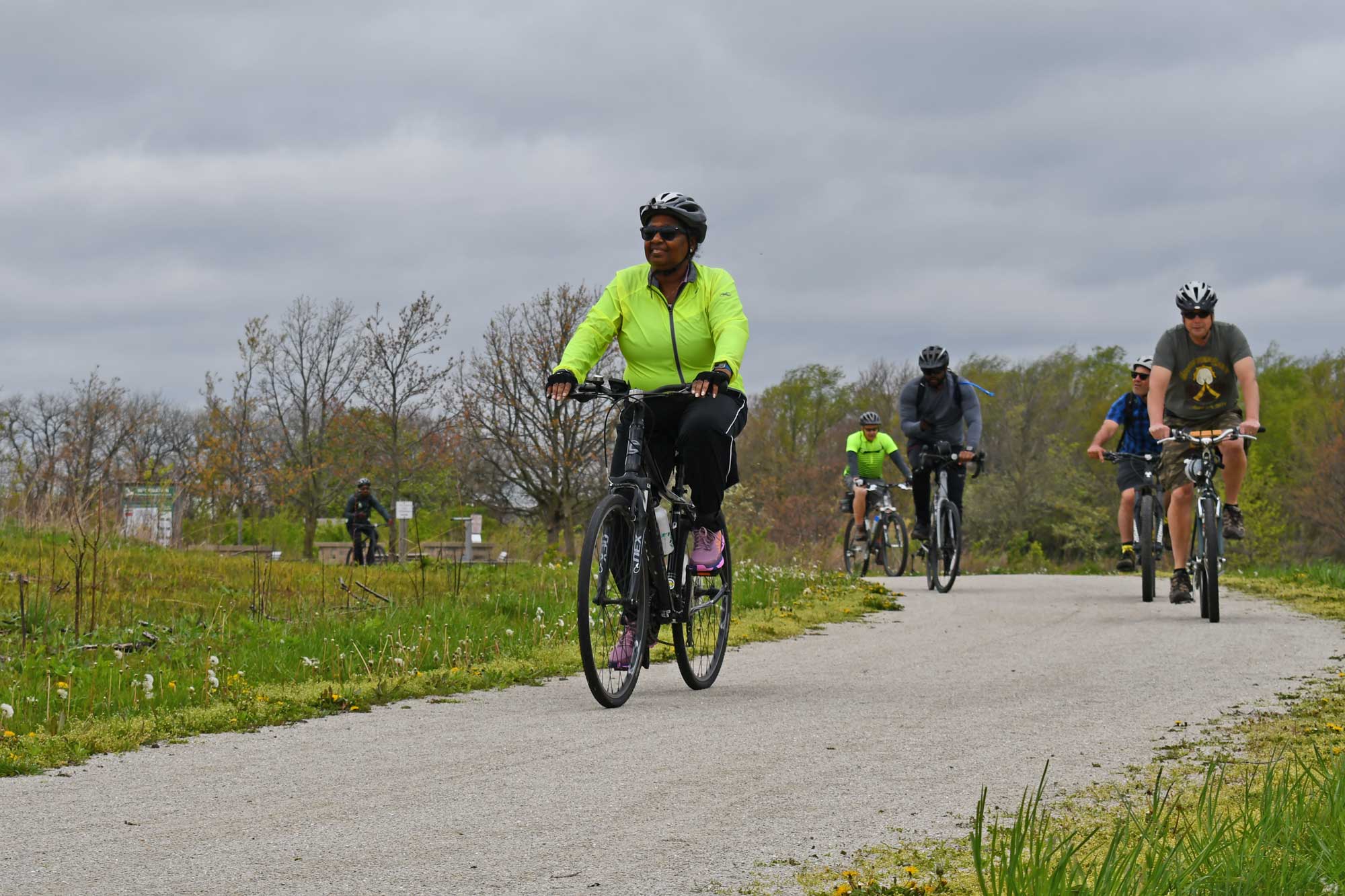 A line of cyclists travel on a crushed limestone trail. 