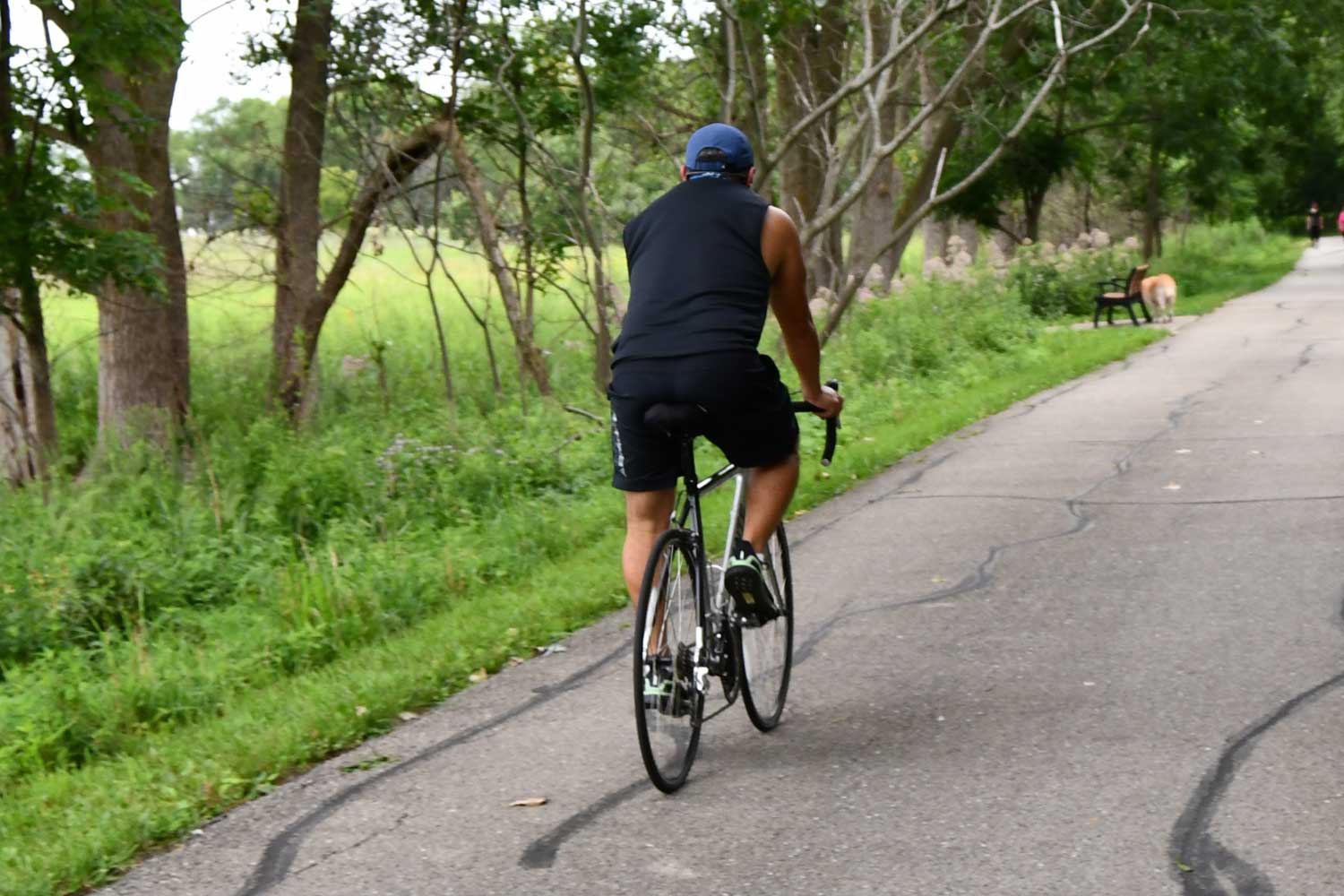 Person riding a bike on a paved trail.