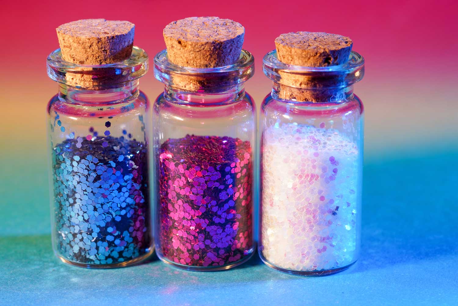Three tubes of colorful glitter.