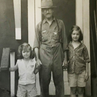 A historic photo of a man and his two daughters