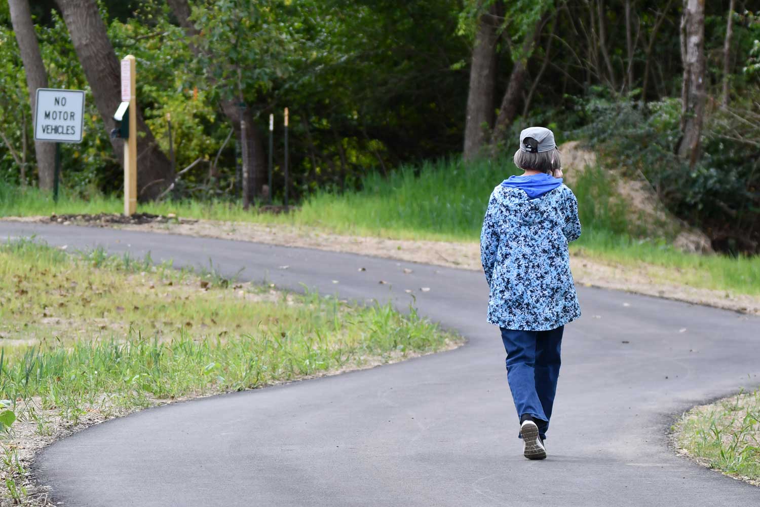 Person walking along a paved trail.
