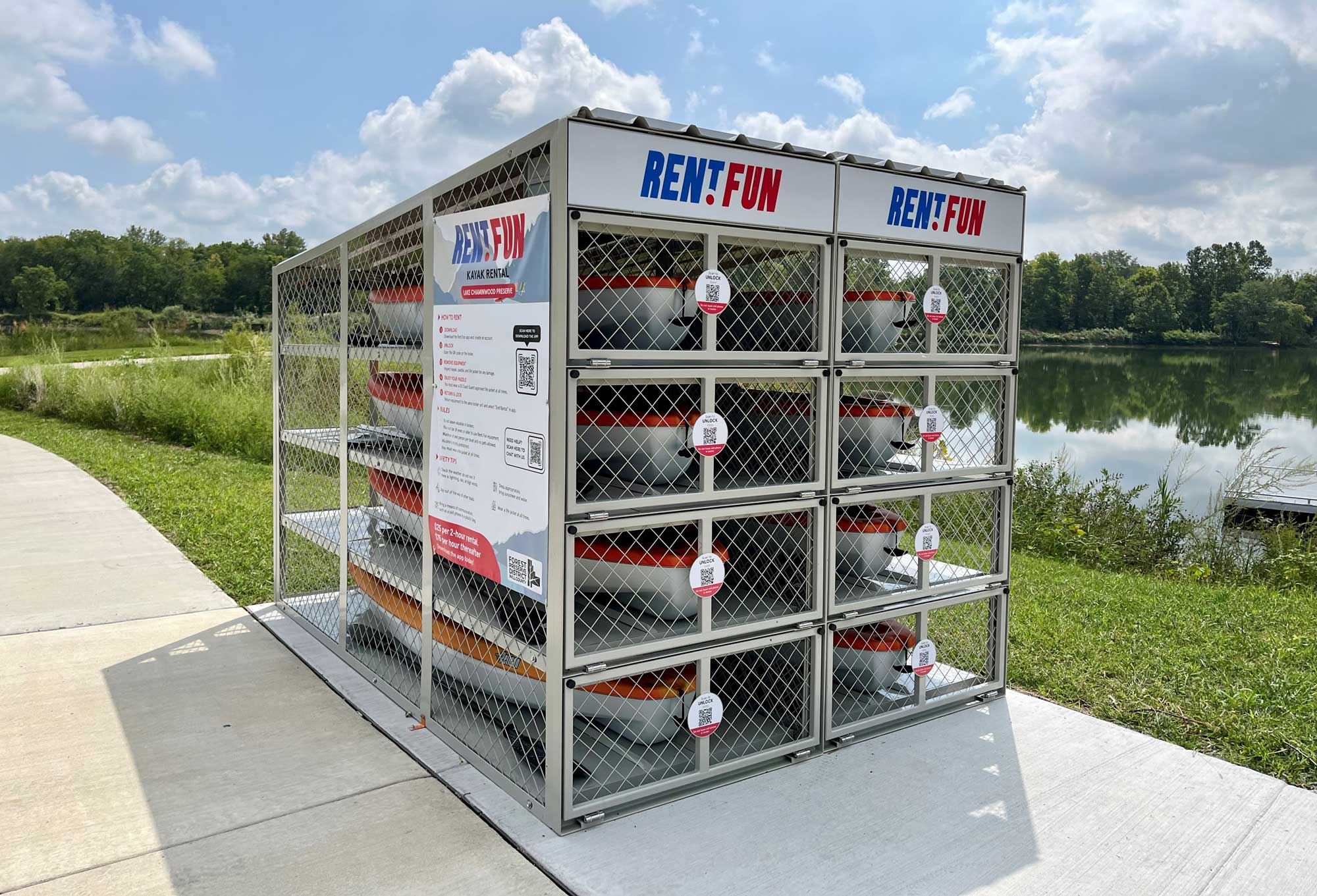 A view of kayak rental lockers next to a lake.