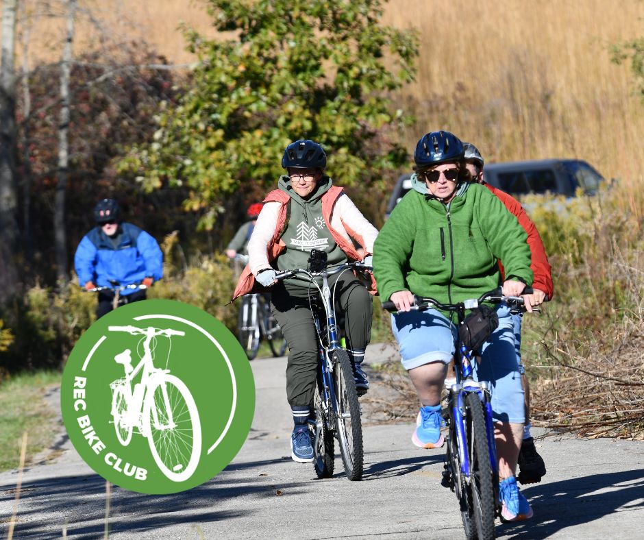 A group of four people riding bikes on a trail.
