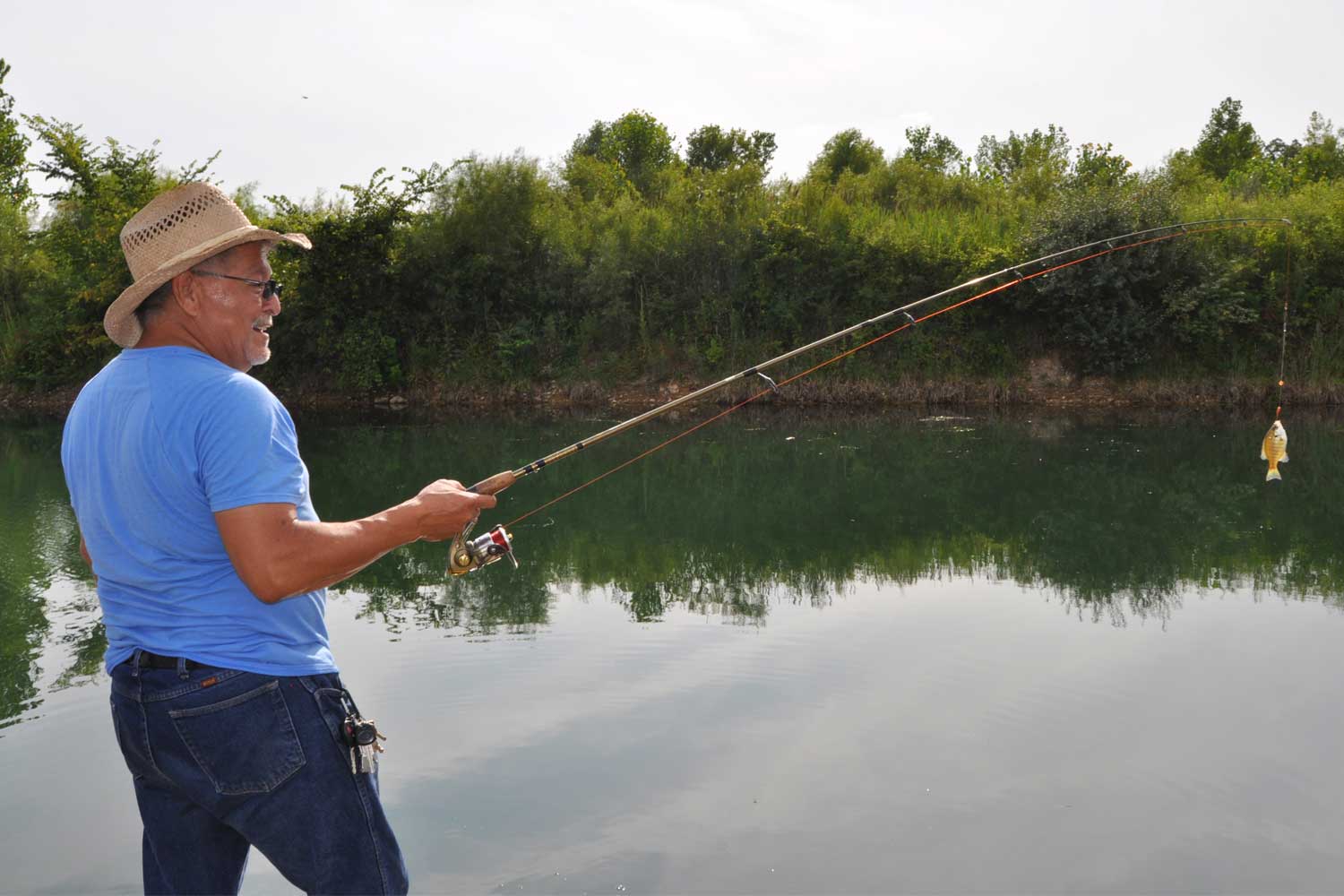 Person fishing with a caught fish on their line.