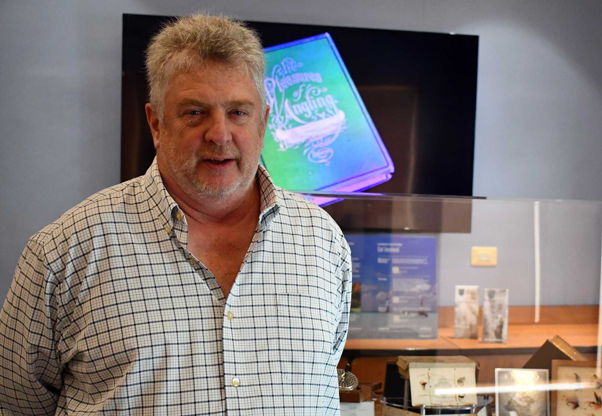 Man stands in the middle of a fly fishing exhibit