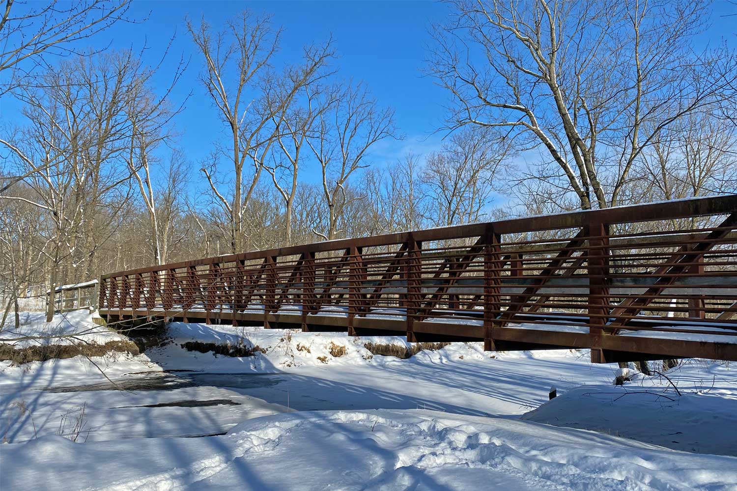 Snow covered trail and bridge at Hickory Creek.