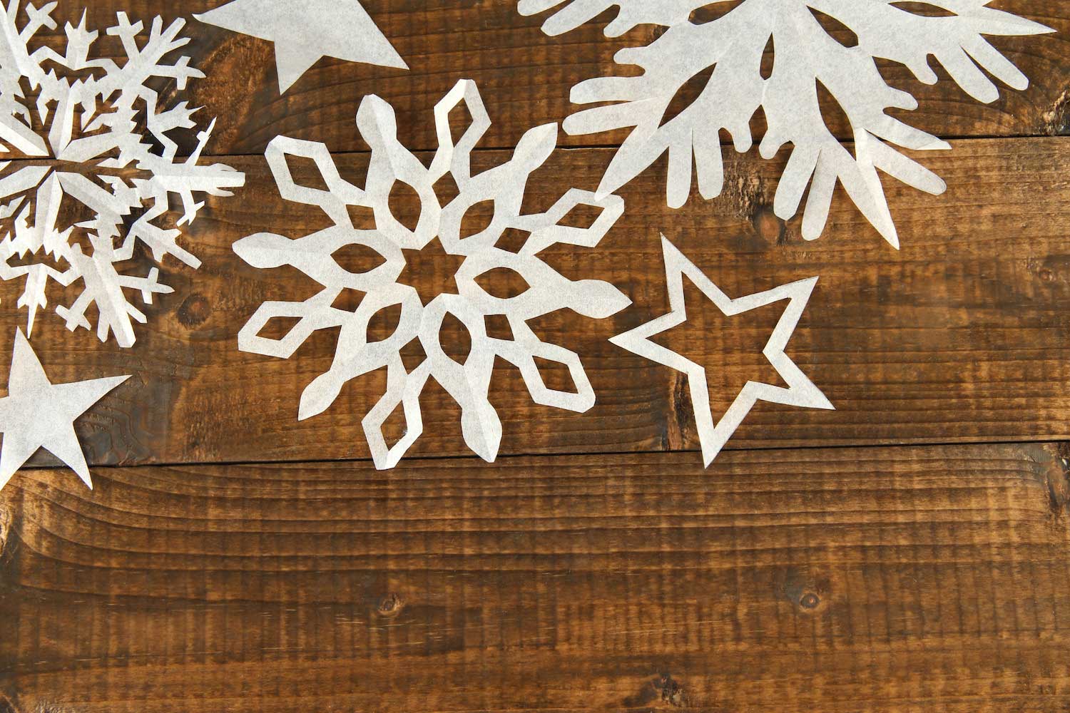 Paper snowflakes on a wooden table.
