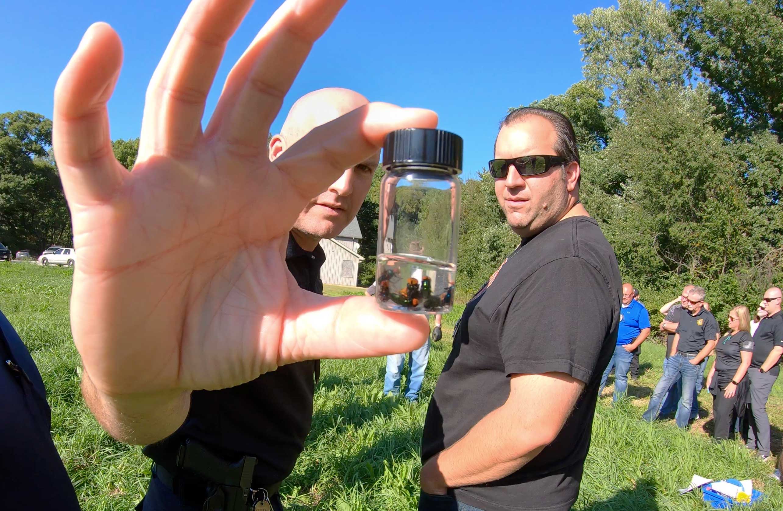 Man holding flies in a jar