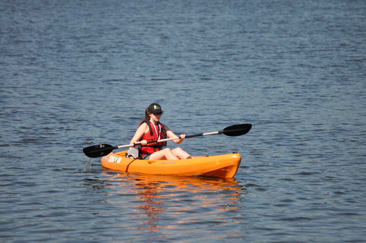 A person kayaking across a lake.