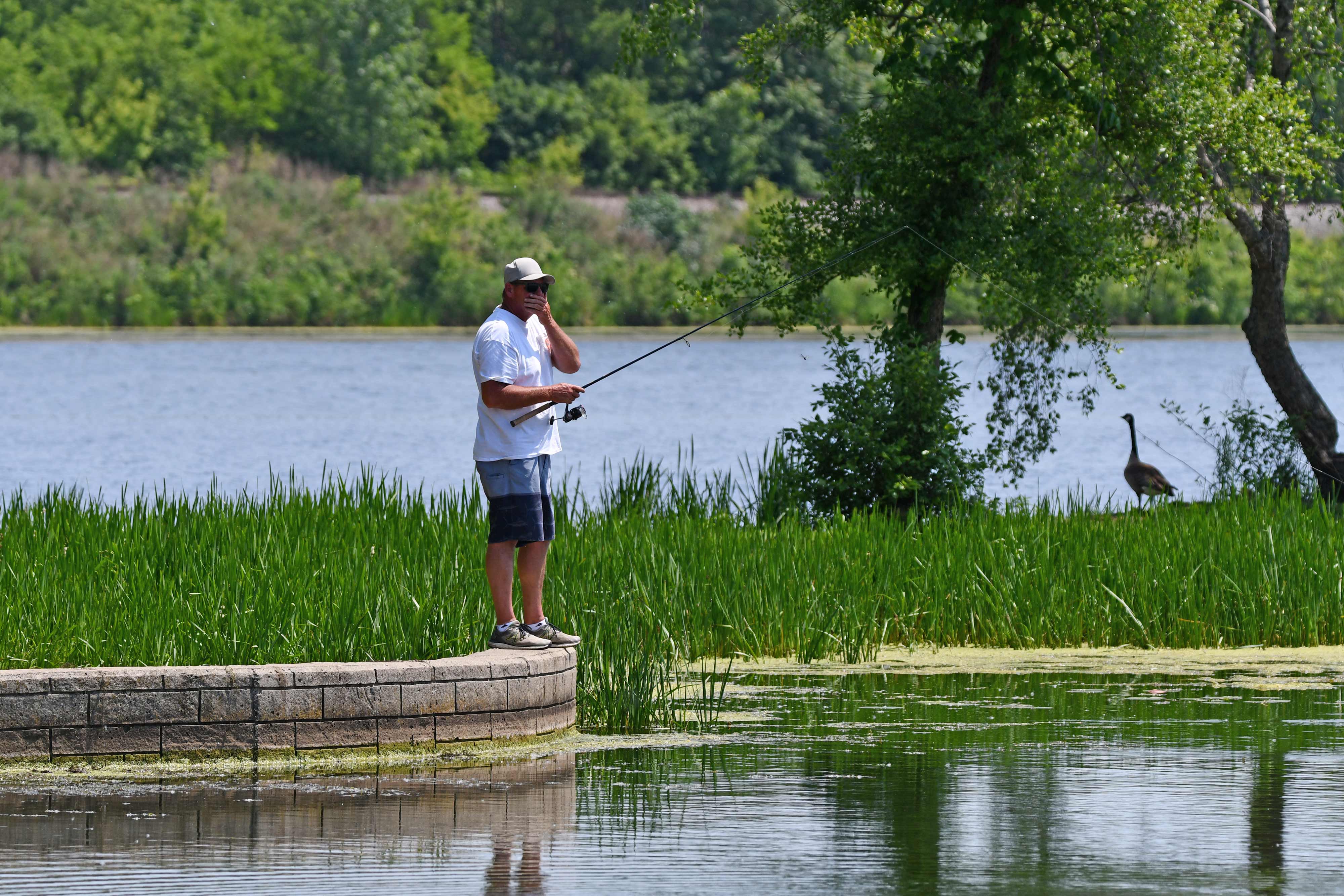 A man fishes along the shore.