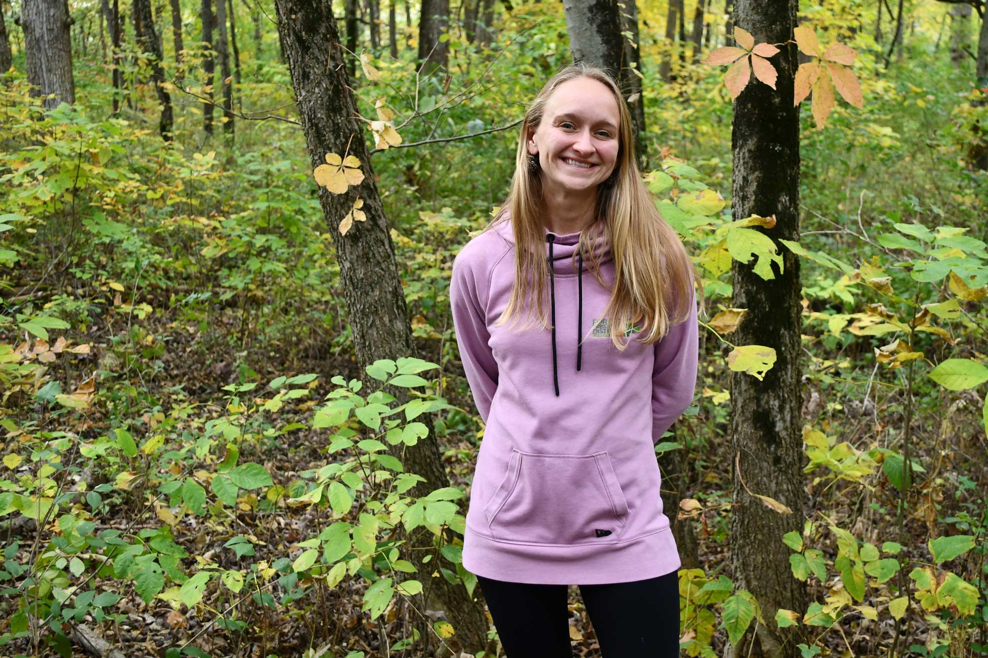 A woman poses in a forest.