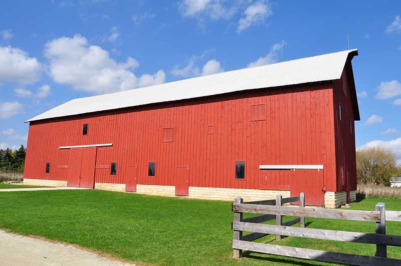A large red barn set against a bright blue sky.
