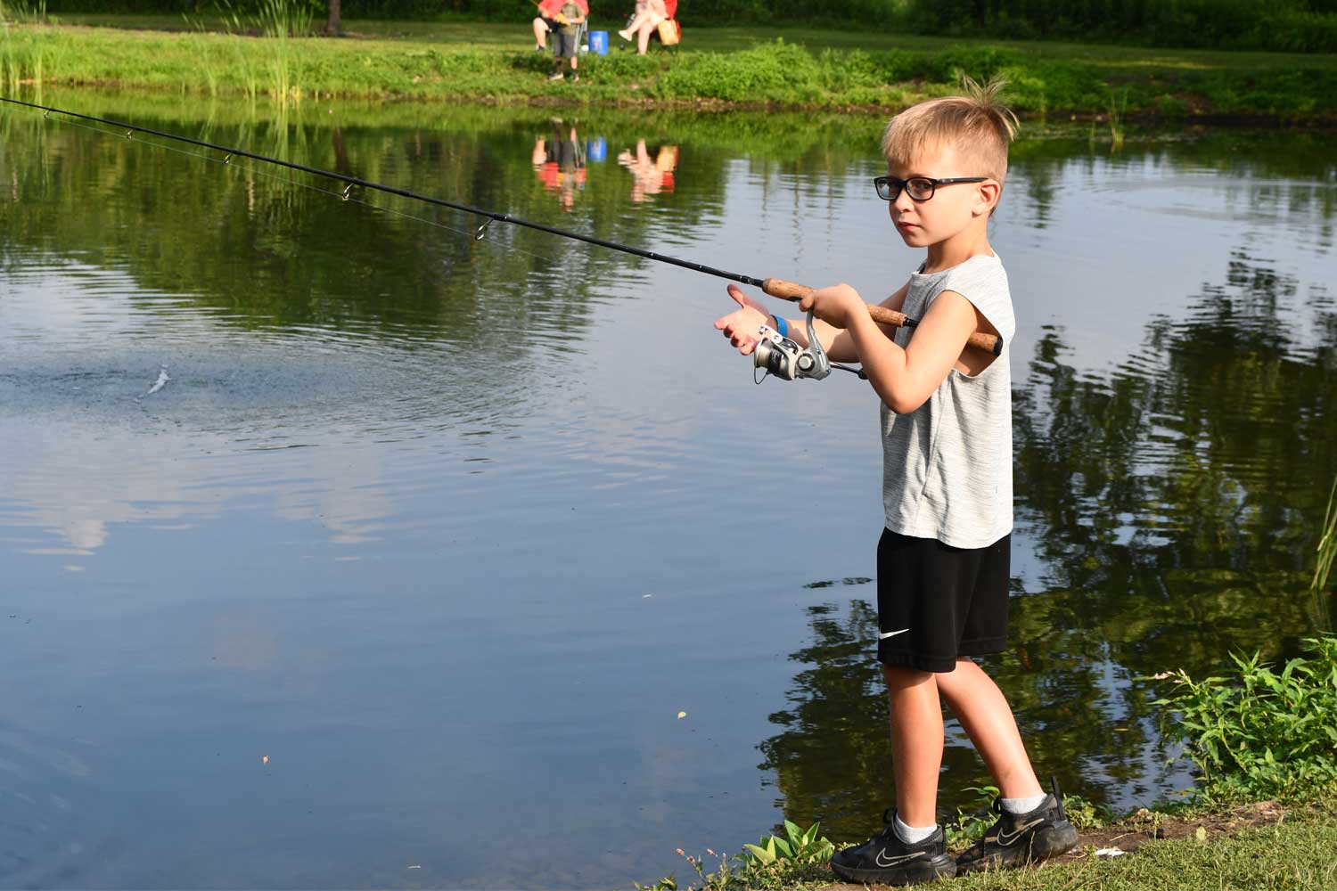 Person fishing with the water in the background.