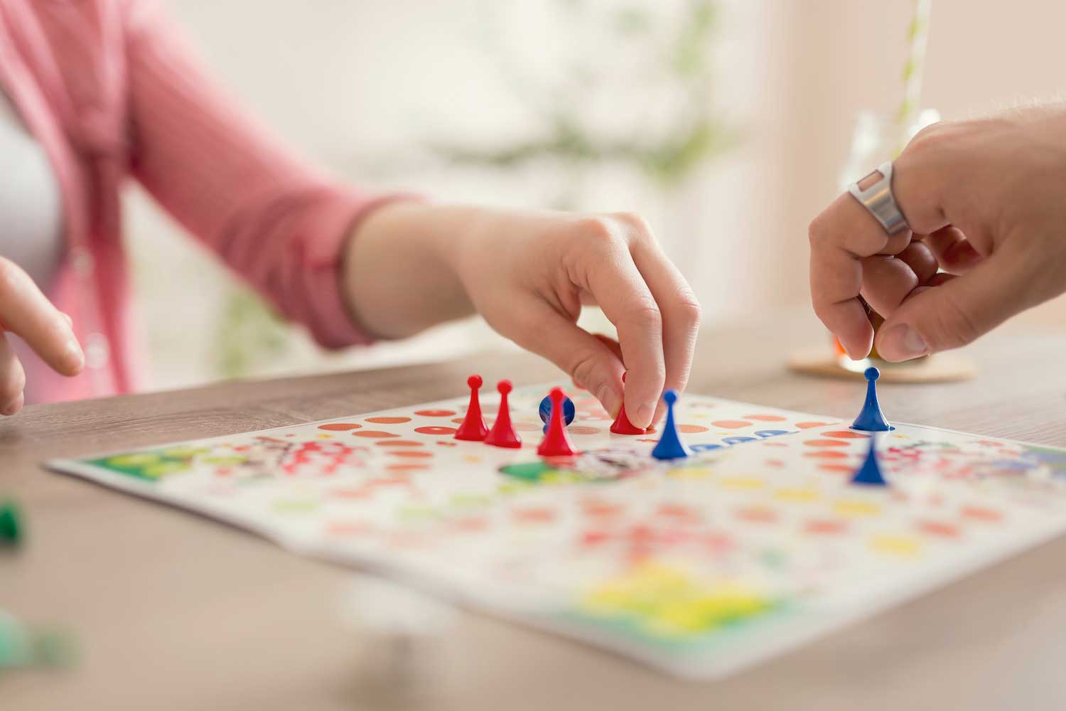 Two people moving the pieces of a board game.