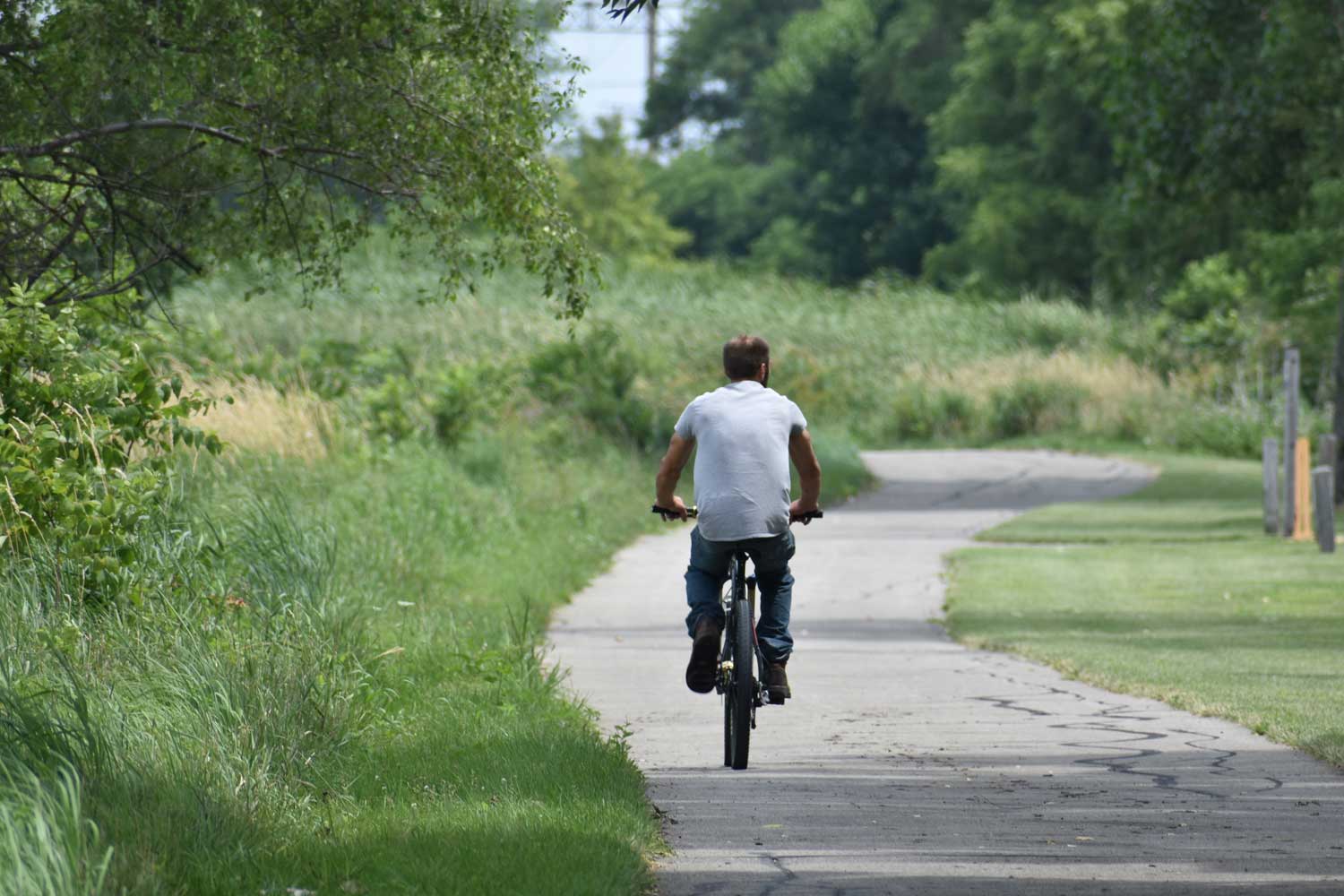 Person riding a bike on a paved trail.