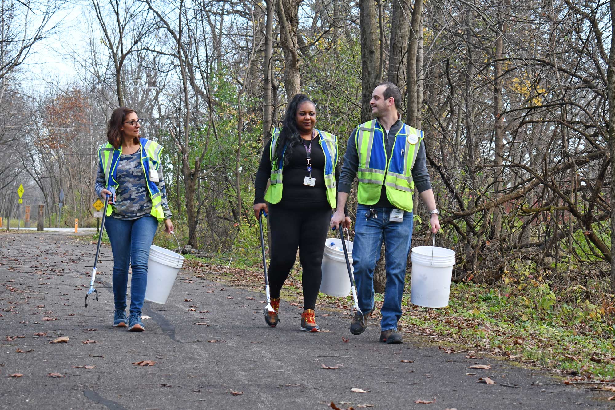 Volunteers from Ikea walk a trail and pick up litter