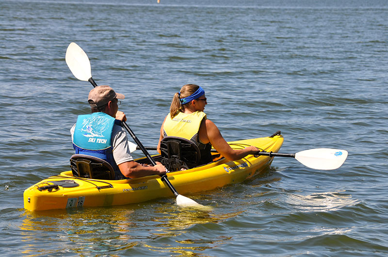Two people on a kayak on a lake.